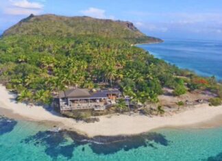 Vomo Island Fiji: A Paradisiacal Retreat in the Pacific A breathtaking sunset over Vomo Island Fiji, showcasing the island's lush greenery against a backdrop of tranquil blue waters and a vibrant sky, epitomizing a luxurious and serene tropical escape