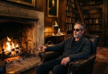 The Cold Stone Cure: Why the Highlands Turn Up the Heat Luxury solo travel retreats guest sitting fireside in a candlelit Scottish Highland drawing room